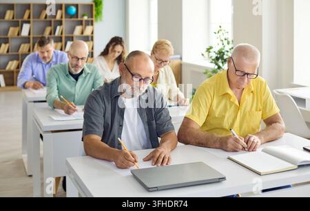 Adult students in classroom training, taking notes during computer learning course Stock Photo