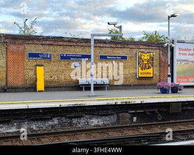 Blue signage on brickwall, a yellow safety band along the platform & a CCTV security camera, Waterloo East railway station, London, UK Stock Photo