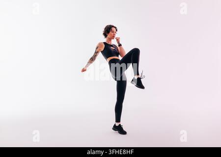 Full length of a young, slim woman doing leg exercises in a studio Stock Photo