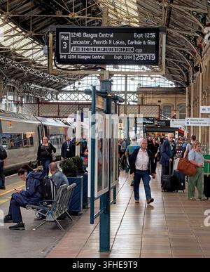 Passengers wait beneath departure boards at Preston railway station in Lancashire on the West Coast Main Line,prior to end of Avanti contract Mar 2027 Stock Photo