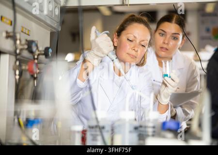 Two women scientists chemists are conducting various experiments in a research laboratory Stock Photo