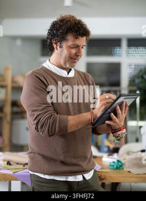 Man tailor makes pattern using tablet Stock Photo