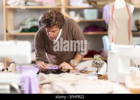 Man tailor makes pattern using tablet Stock Photo