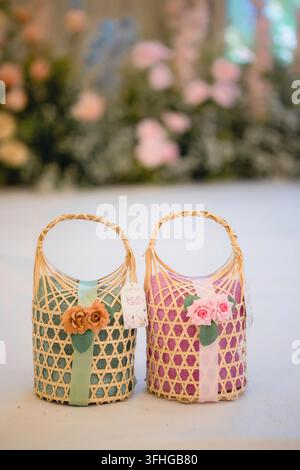 Two mini woven bamboo baskets decorated with colorful ribbons and fabric flowers Stock Photo