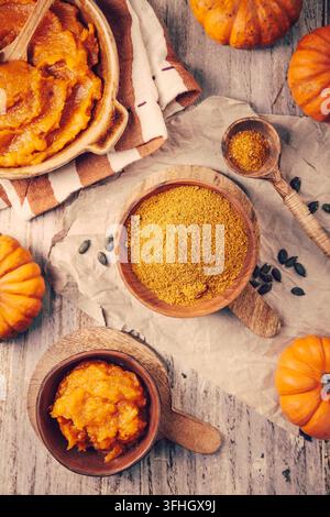 Wooden bowl filled with aromatic pumpkin spice blend on a rustic kitchen table setting Stock Photo