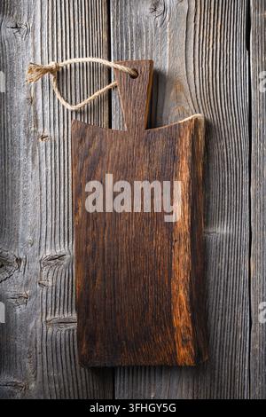 Small knife with wooden handle lying on an old cutting board on rusty aged table Stock Photo
