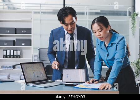 Business professional analyzing financial data on digital tablet dashboard with calculator and laptop, representing accounting software, ERP system in Stock Photo