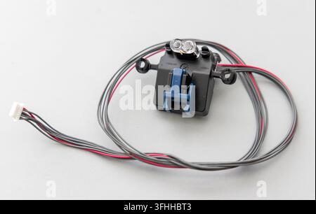 A black electronic sensor module with wires is on a gray surface Stock Photo