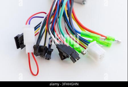 A colorful bundle of electrical wires with various connectors is on white Stock Photo