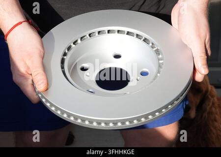 A man is unloading a box from a truck with a brake disc Stock Photo