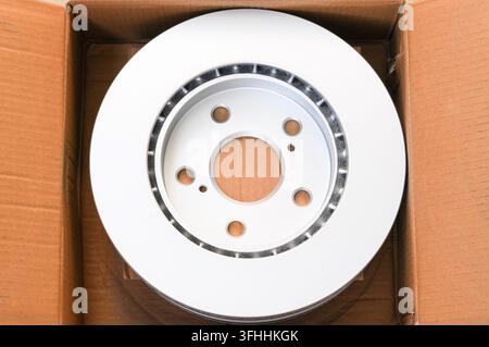 Car brake disc in box close up. Automotive spare parts. Stock Photo