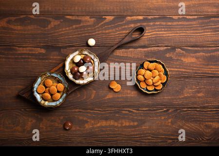 Assorted Dutch kruidnoten cookies displayed in decorative bowls on a wooden surface, featuring traditional Sinterklaas treats for the holiday season Stock Photo