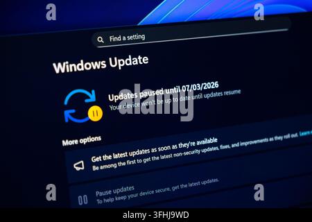Poznan, Poland - February 15, 2026: Software configuration interface showing a suspended operating system update dashboard that indicates a postponed Stock Photo