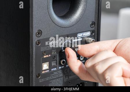 Poznan, Poland - January 4, 2026: Klipsch powered monitor speaker volume dial adjustment by a finger to fine tune acoustic performance for a premium h Stock Photo