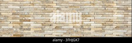Beige and cream stone wall showing horizontal stacked bricks with natural texture Stock Photo