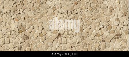 Stone wall featuring natural rocks and rough mortar, forming a beige textured background Stock Photo