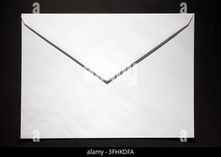 closed envelope with white spot light on black background Stock Photo