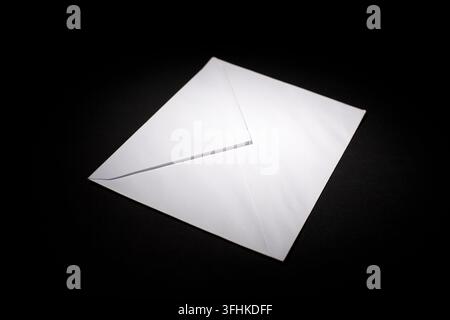 closed envelope with white spot light on black background Stock Photo