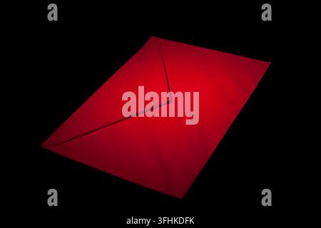 closed envelope with red spot light on black background Stock Photo