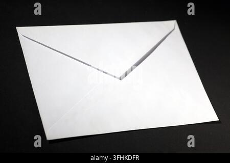 closed envelope with white spot light on black background Stock Photo