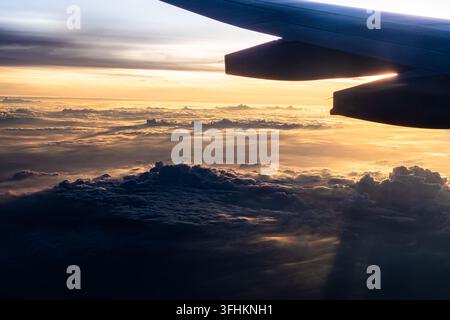Stunning Aerial View of Clouds and Sky During Sunset from an Airplane Window: Capturing the Beauty of Nature from Above. Stock Photo