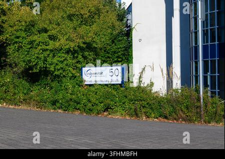 Iserlohn, Germany - August 13, 2026: Entrance sign of Witten Herdecke University beside green bushes and an institutional building facade. Stock Photo