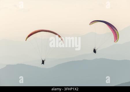 Paragliding flight in the air over the mountains. Stock Photo