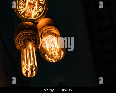 Different types of vintage glowing light bulbs on black. Edison lamps Stock Photo