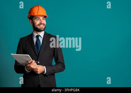 Young engineer businessman in suit jacket and construction helmet with documents, building project, report. Businessman isolated on blue background as Stock Photo