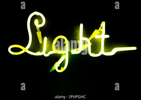 Illuminated letters written light on dark black background. Neon yellow words. Abstract picture. High quality photo Stock Photo