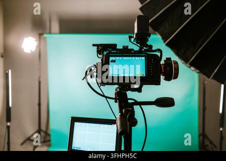 Modern studio with professional video camera and green screen - chromakey. TV camera for recording live show. Broadcasting equipment. Television indus Stock Photo