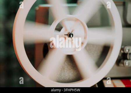 Coils with tape film turning. Analog player. Retro old-fashioned 8mm projector playing movie at theater. Entertainment, nostalgi Stock Photo