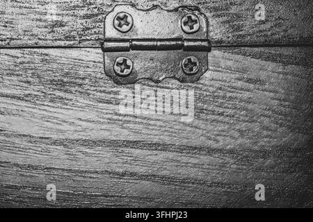Black and white macro of antique metal hinge with screws on wood Stock Photo