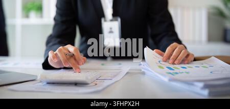 Businesswoman accountant using calculator and laptop for financial data saving in office room, Business financial, tax, accounti Stock Photo