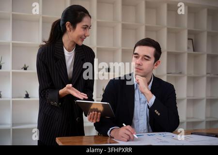Team business of diverse partner business woman discuss project on laptop sitting at table in office. Two colleague of professio Stock Photo