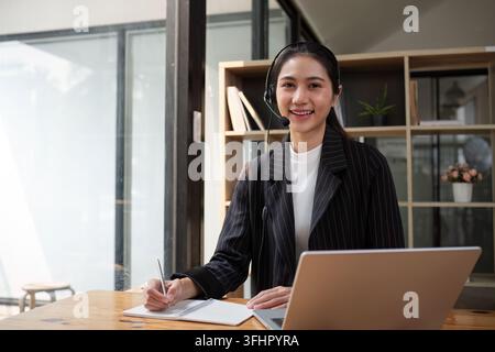 Call center friendly woman asian in office for customer service, technical support and advice, contact and communication with em Stock Photo