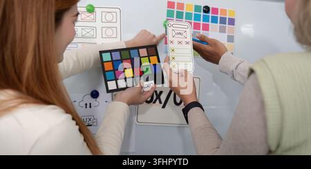 ux developer and ui designer presenting mobile app interface design on whiteboard in meeting at office. Creative digital development mobile app agency Stock Photo