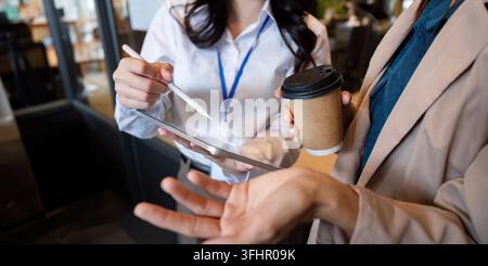 Business team woman working using digital tablet tech discussing financial market data standing at corporate office meeting. Stock Photo