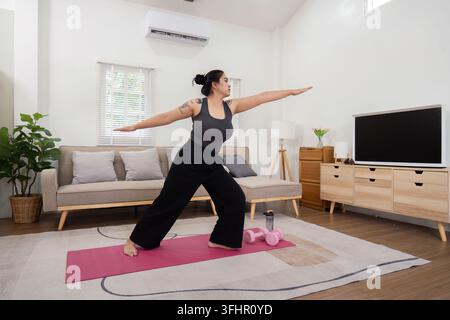 Inspirational Journey of a Plus Size Woman Practicing Yoga at Home, Embracing a Healthy Lifestyle and Weight Loss Transformation Stock Photo