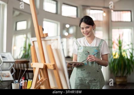 Talented Artist Painting in Bright Workshop. Creative Process in Modern Art Studio with Natural Light and Artistic Tools Stock Photo
