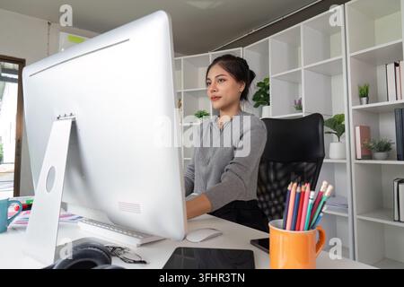 Professional Graphic Designer Working on Computer in Modern Office with Creative Workspace and Stylish Decor Stock Photo