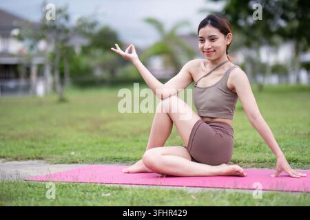 Young Woman Practicing Seated Yoga Pose on Mat Outdoors Stock Photo
