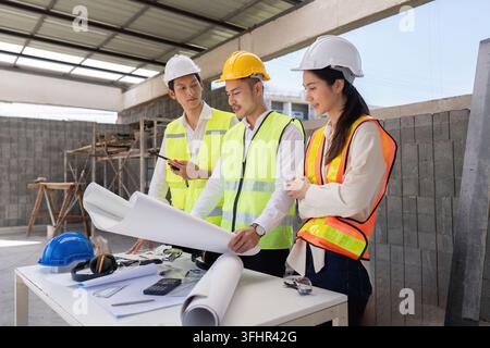 Engineers discussing construction blueprints on site, focusing on project execution and design implementation. Stock Photo