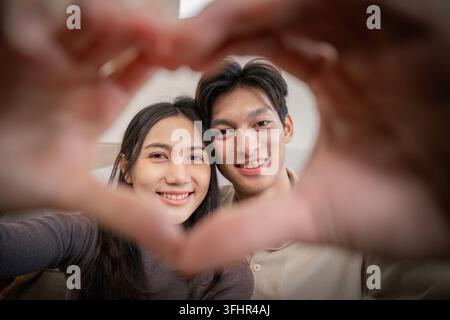 Young couple making a heart shape with their hands Stock Photo