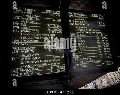 Electronic train departure boards at Leeds railway station displaying services, platforms, times and delays. Stock Photo