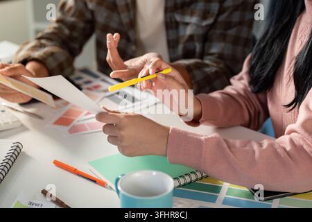 A team collaborates on graphic design projects sharing ideas and visual concepts in a modern office setting. Stock Photo