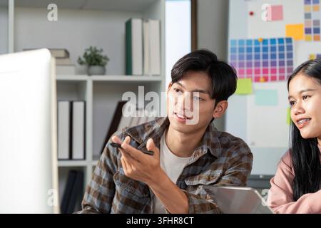 A design team collaborates on graphics showcasing creativity and teamwork in a modern office setting. Stock Photo