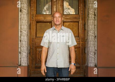 Bald middle-aged man smiling happy walking in the city against the background Stock Photo