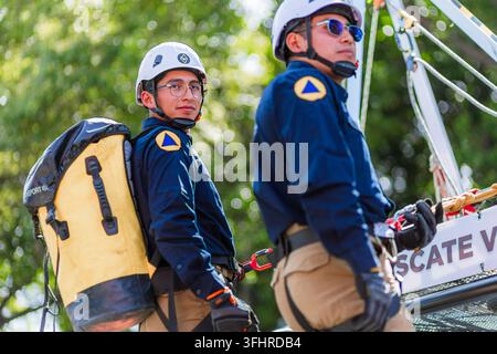 Puebla, Mexico - September 16, 2026: Two rescue workers wearing helmets and safety gear take part in the Independence Day parade. Stock Photo