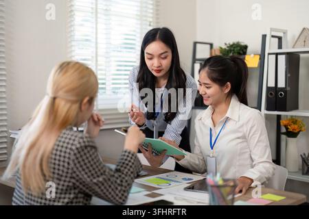Diverse business team sharing ideas with charts and notes in a meeting. Stock Photo